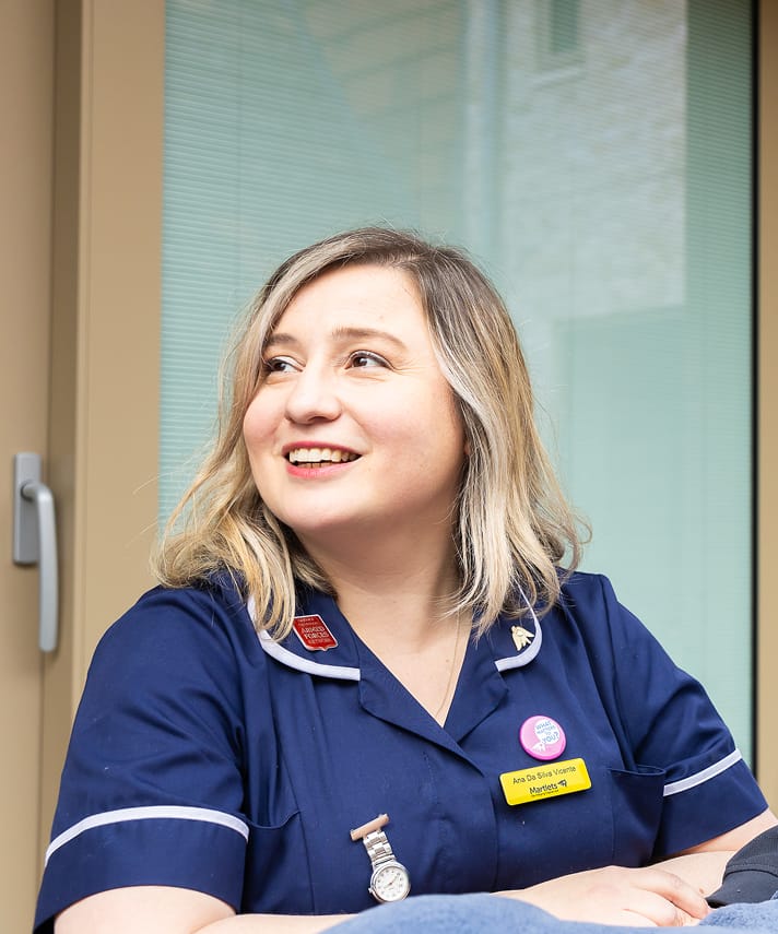 Professional Southern Hospice Group nurse in uniform, smiling outside a facility.